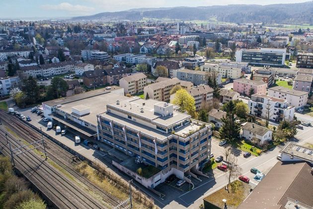 Eine Luftaufnahme eines grossen Gebäudes mitten in der Stadt Dübendorf.