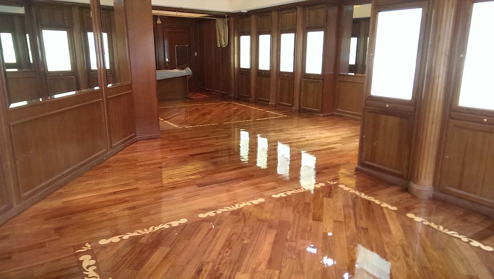 A large room with a wooden floor and lots of windows.