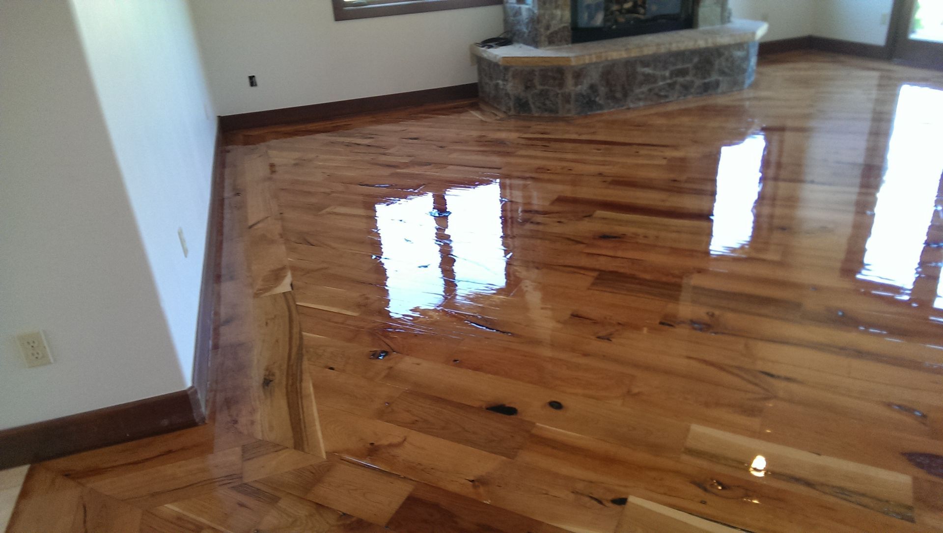 A living room with hardwood floors and a fireplace.