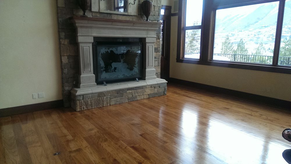 A living room with hardwood floors and a fireplace.