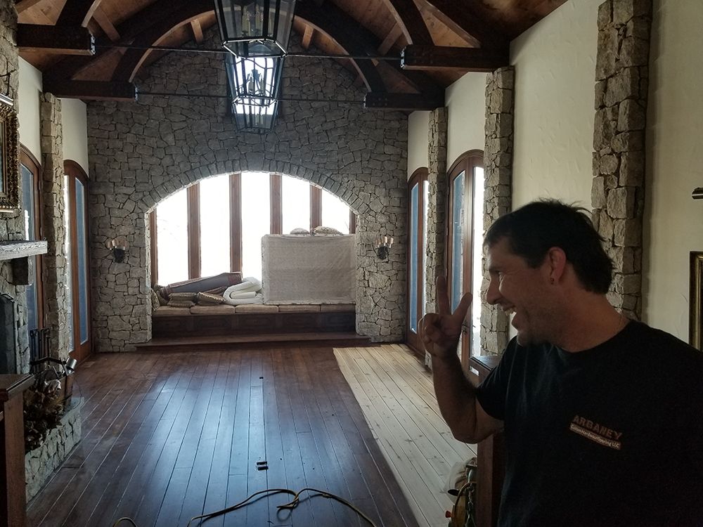 A man in a black shirt is standing in a hallway with a large window