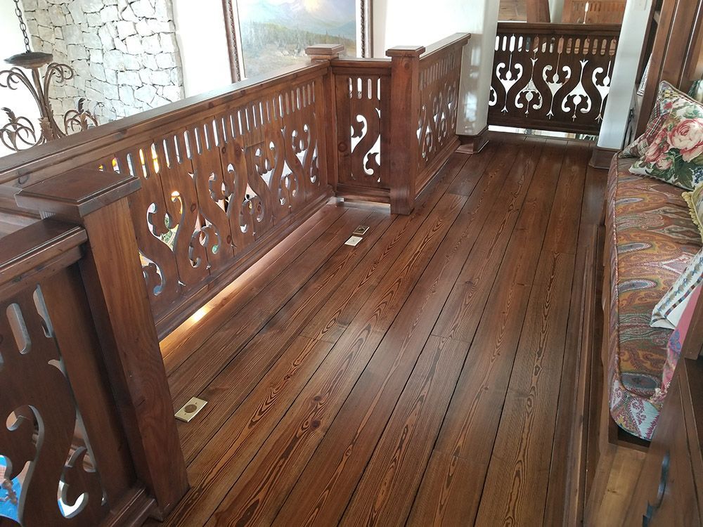 A balcony with a wooden railing and a wooden floor