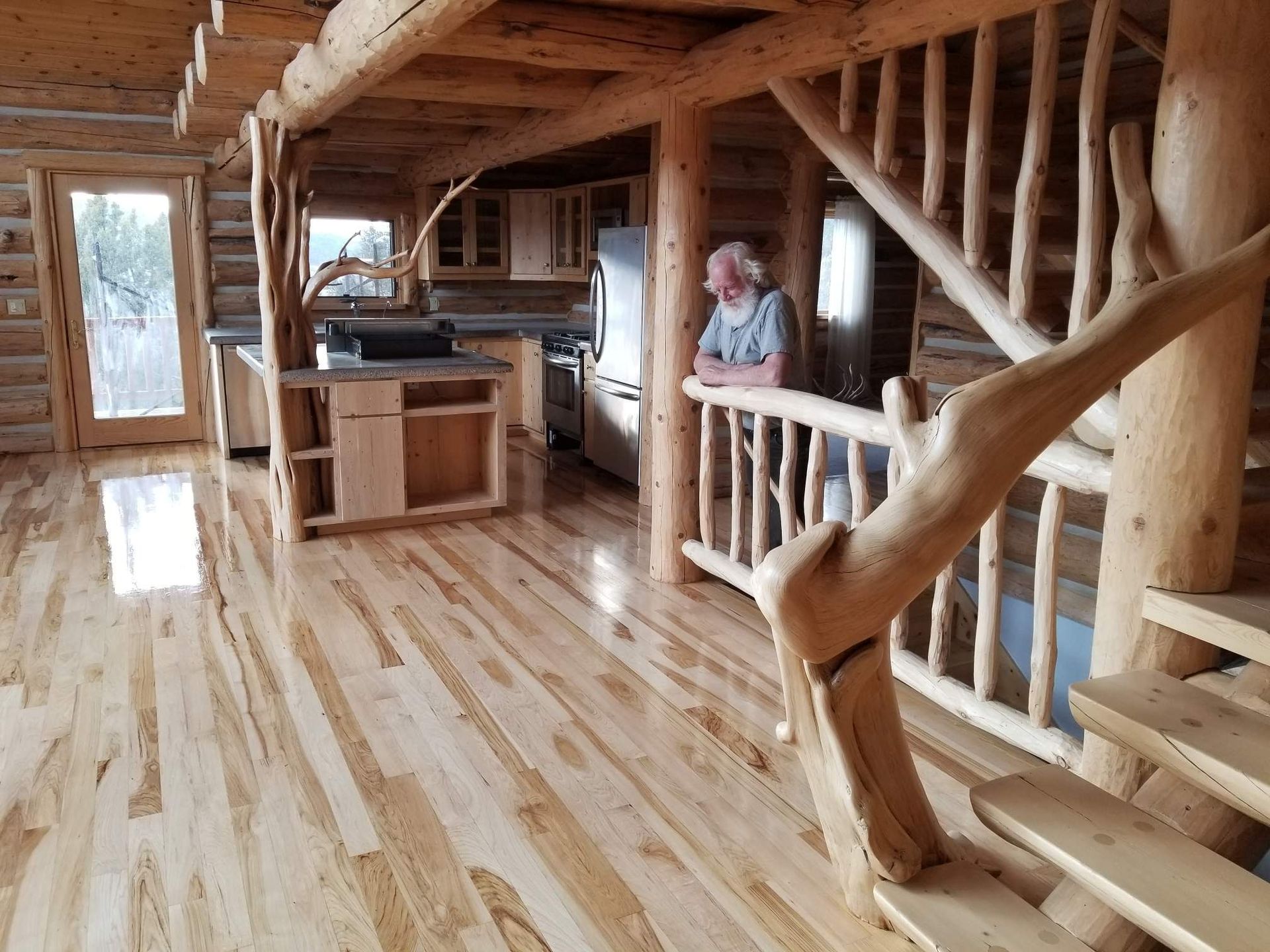 A man leaning on a railing in a log cabin