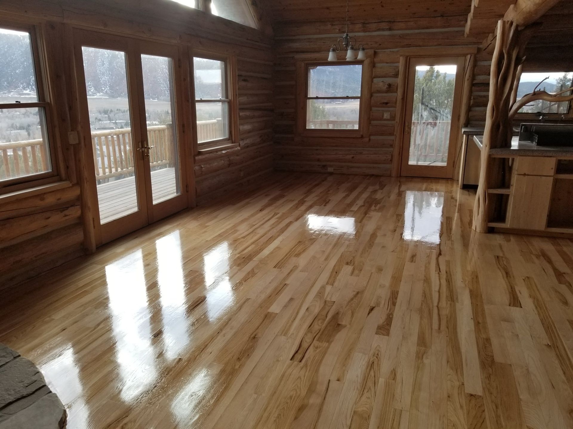 A log cabin with a wooden floor and lots of windows
