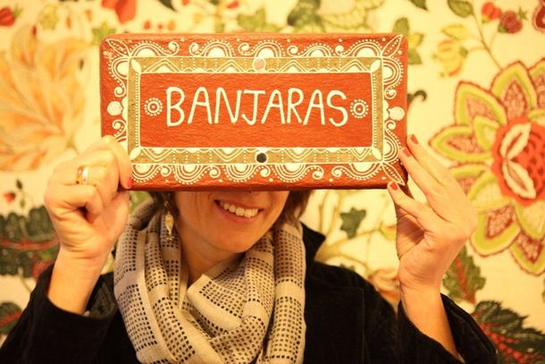 Donna che tiene davanti al viso un cartello con la scritta 