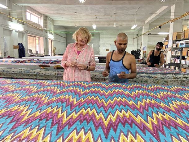 Donna e operaio esaminano un tessuto a zigzag colorato in una fabbrica.