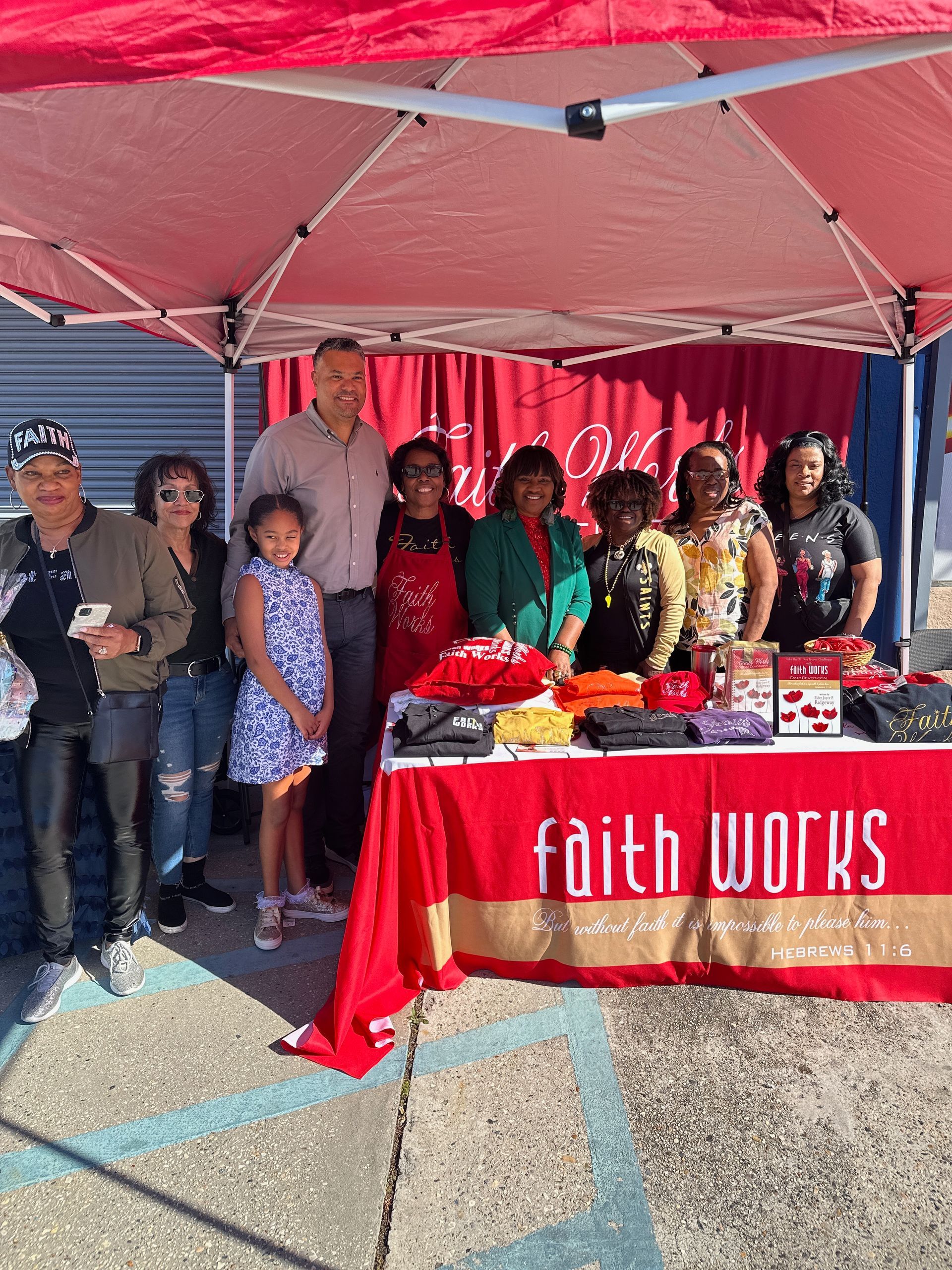 Man in vest and woman in orange jacket pose together indoors.