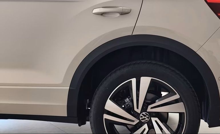 Ruota posteriore beige e pneumatico nero con cerchio color argento e parafango nero. Marchio Volkswagen.