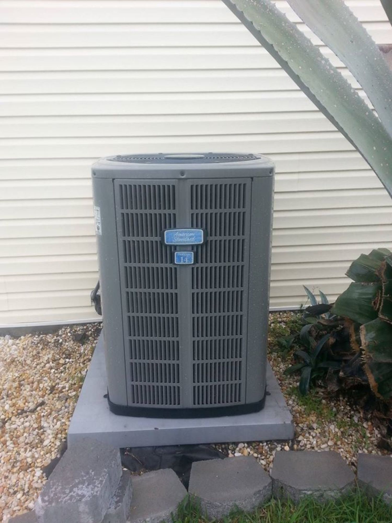 An air conditioner is sitting outside of a house