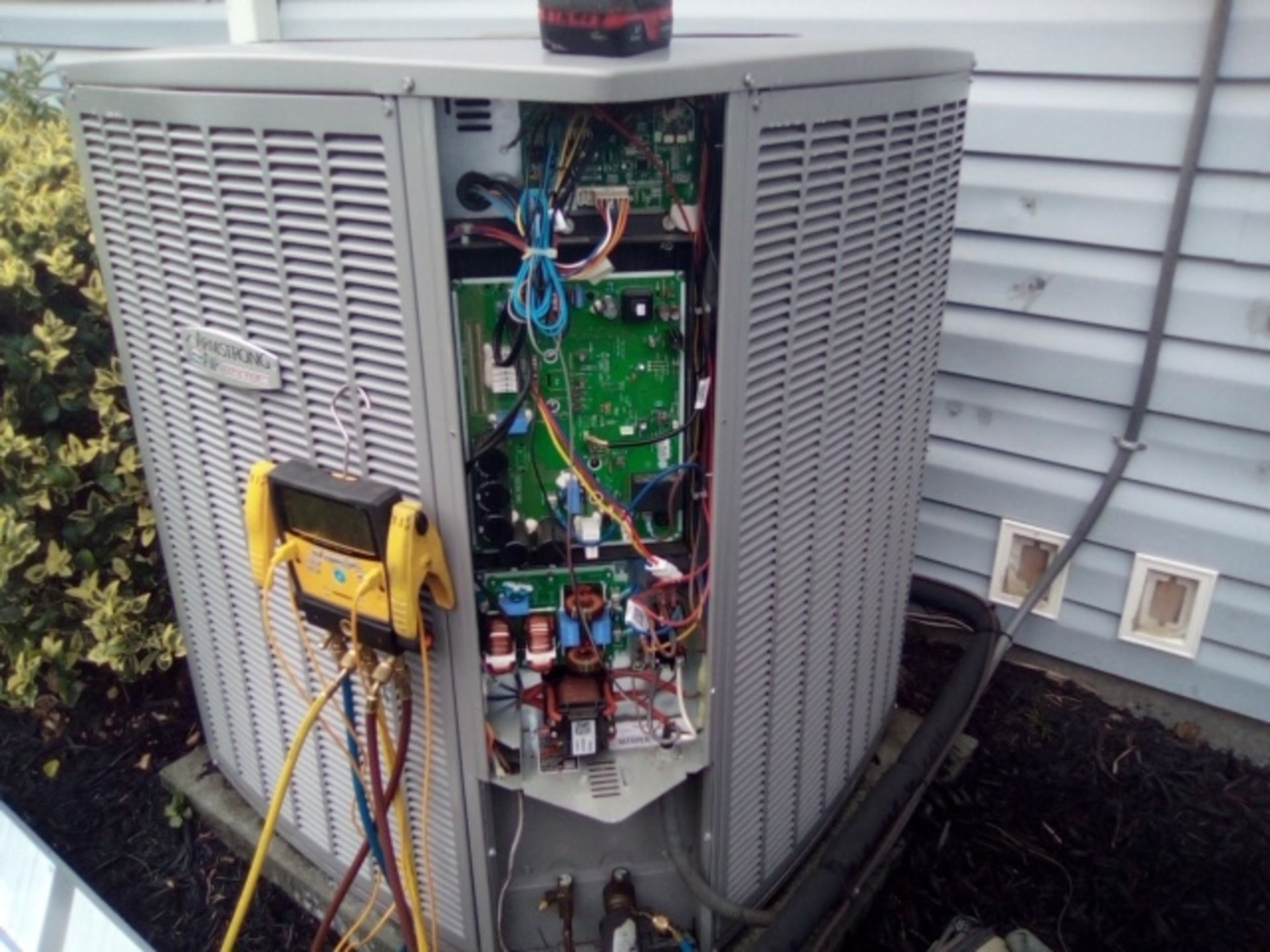 An air conditioner is being serviced by a technician