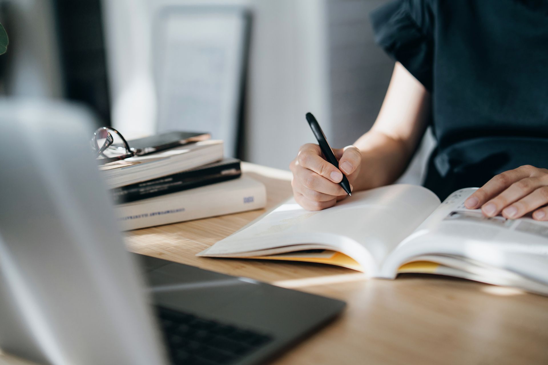 Woman writing in a notebook at a desk