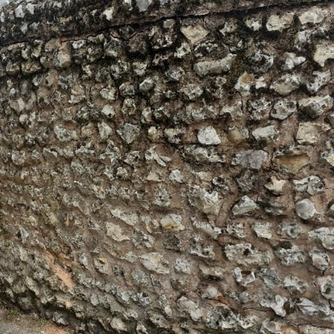 Stone wall with various sized gray rocks.