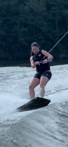 A woman is riding a wakeboard on a lake.