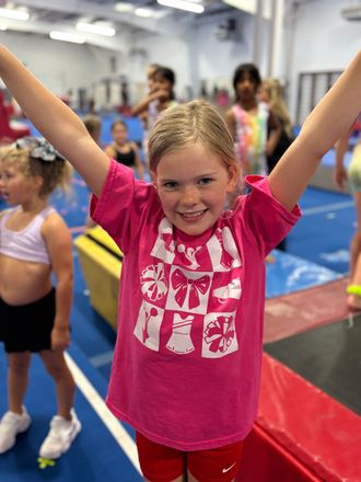 A young girl is jumping on a trampoline in a gym