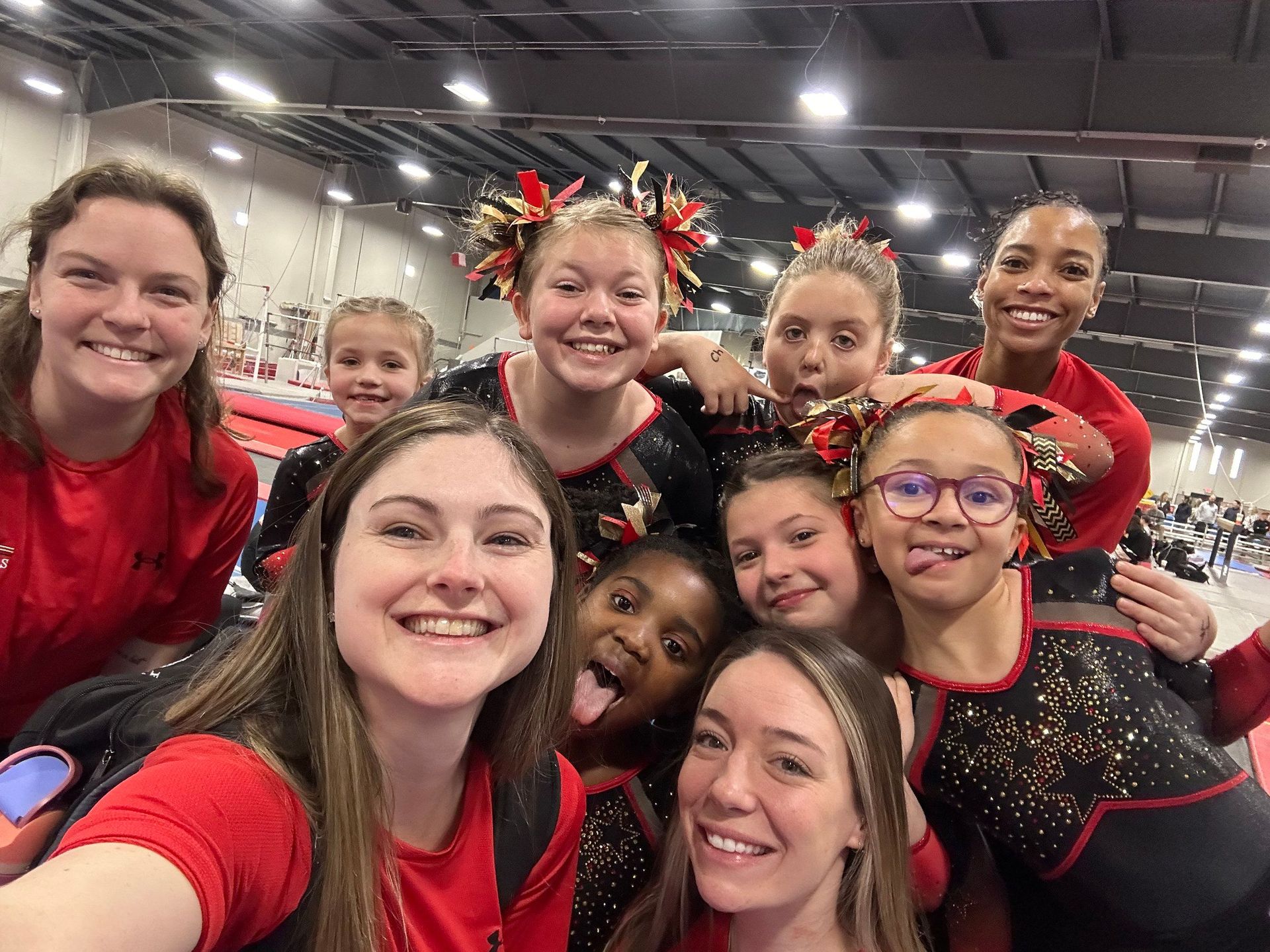 A group of young girls are posing for a selfie in a gym.