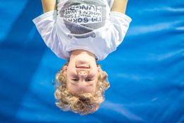 boy hanging upside down and smiling