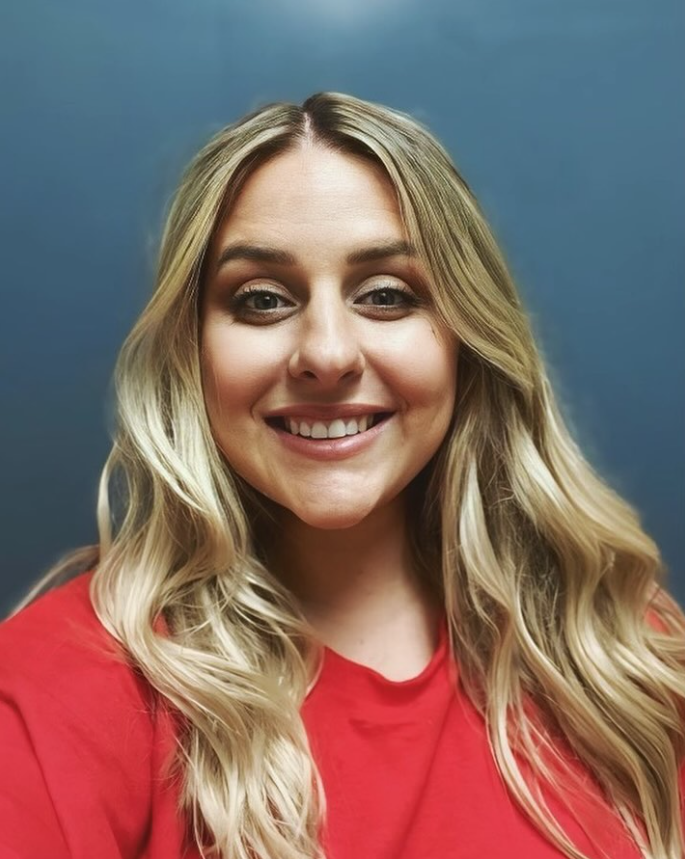 The woman is wearing a red shirt and smiling