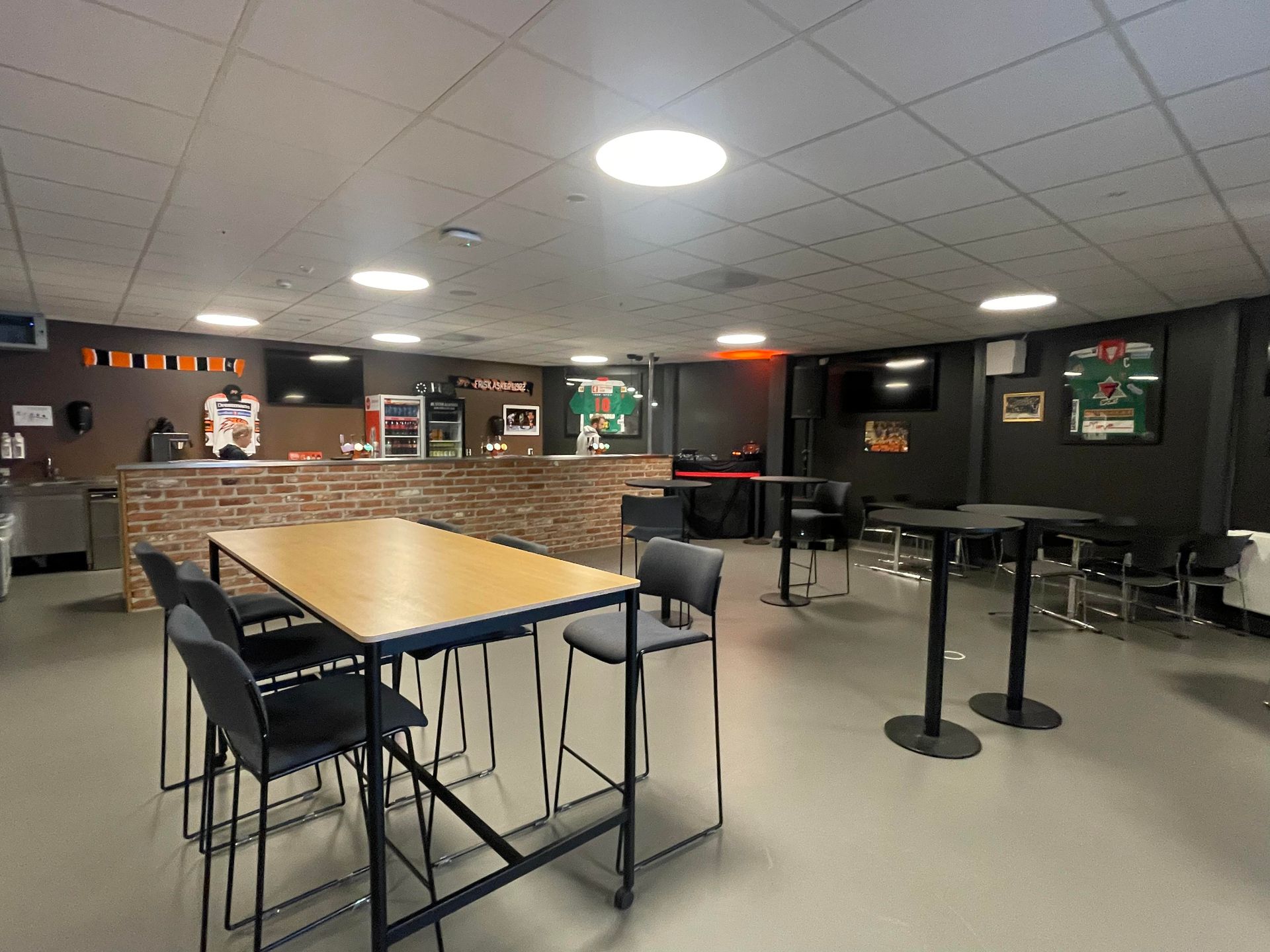 et stort rom med bord og stoler i.