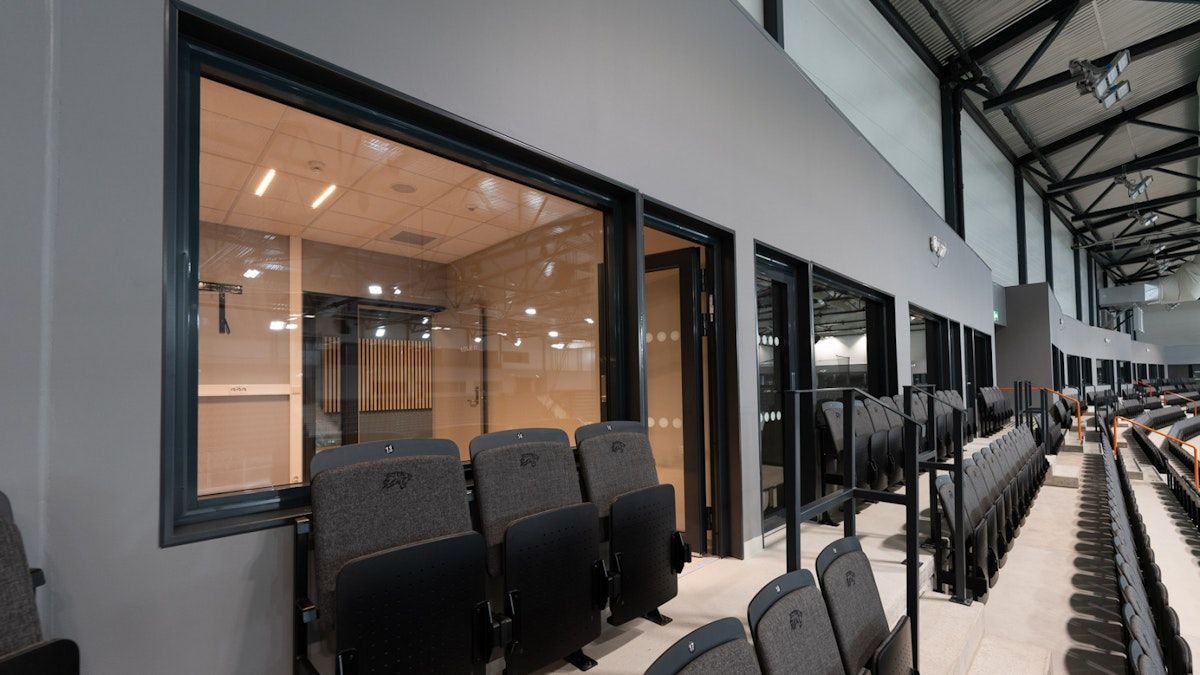 en rad med tomme seter på et stadion med et stort vindu .