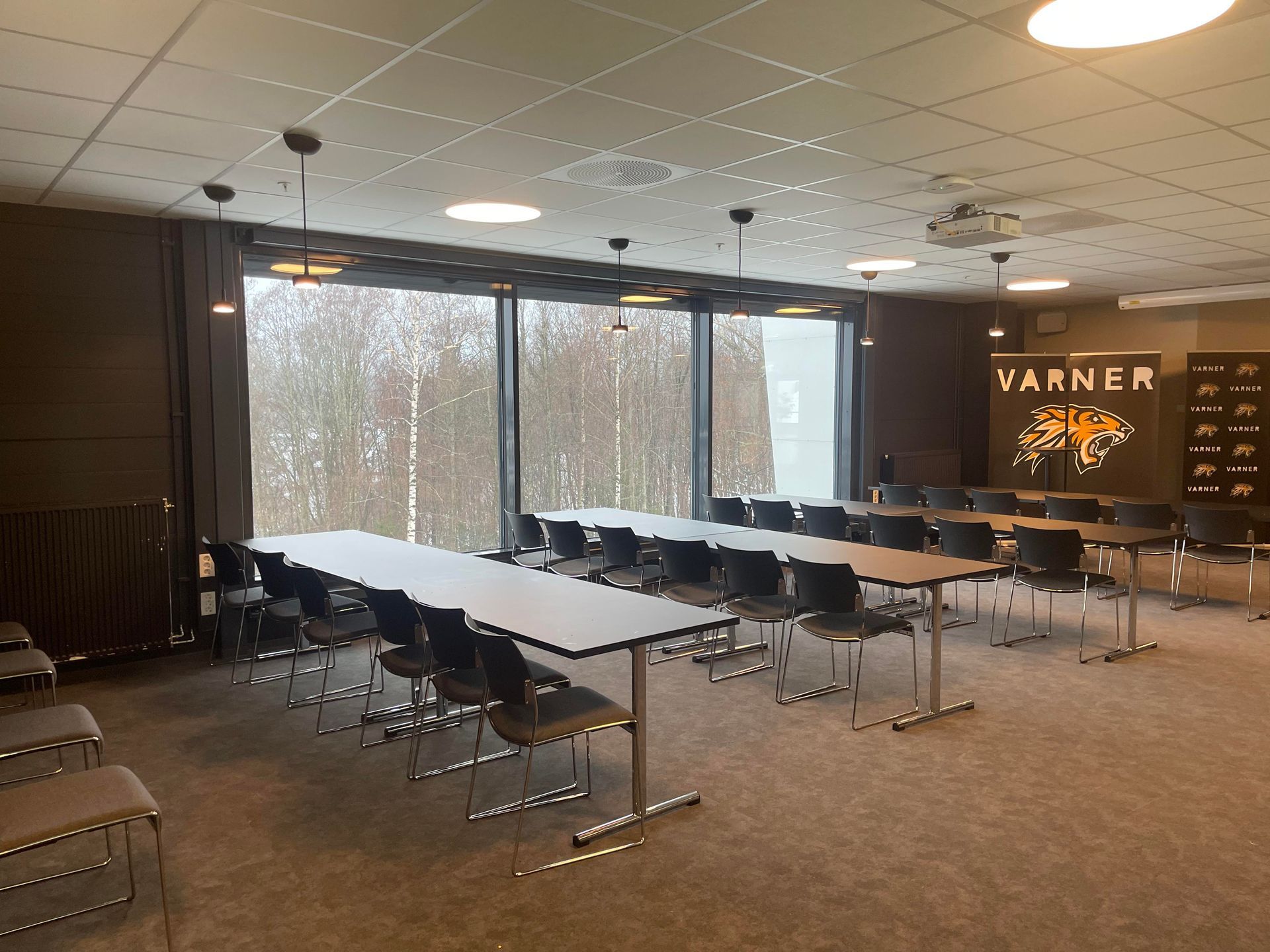 et stort rom med bord og stoler og et skilt hvor det står varner