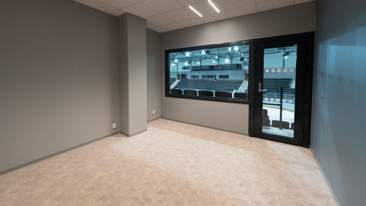 et tomt rom med et stort vindu og en dør .