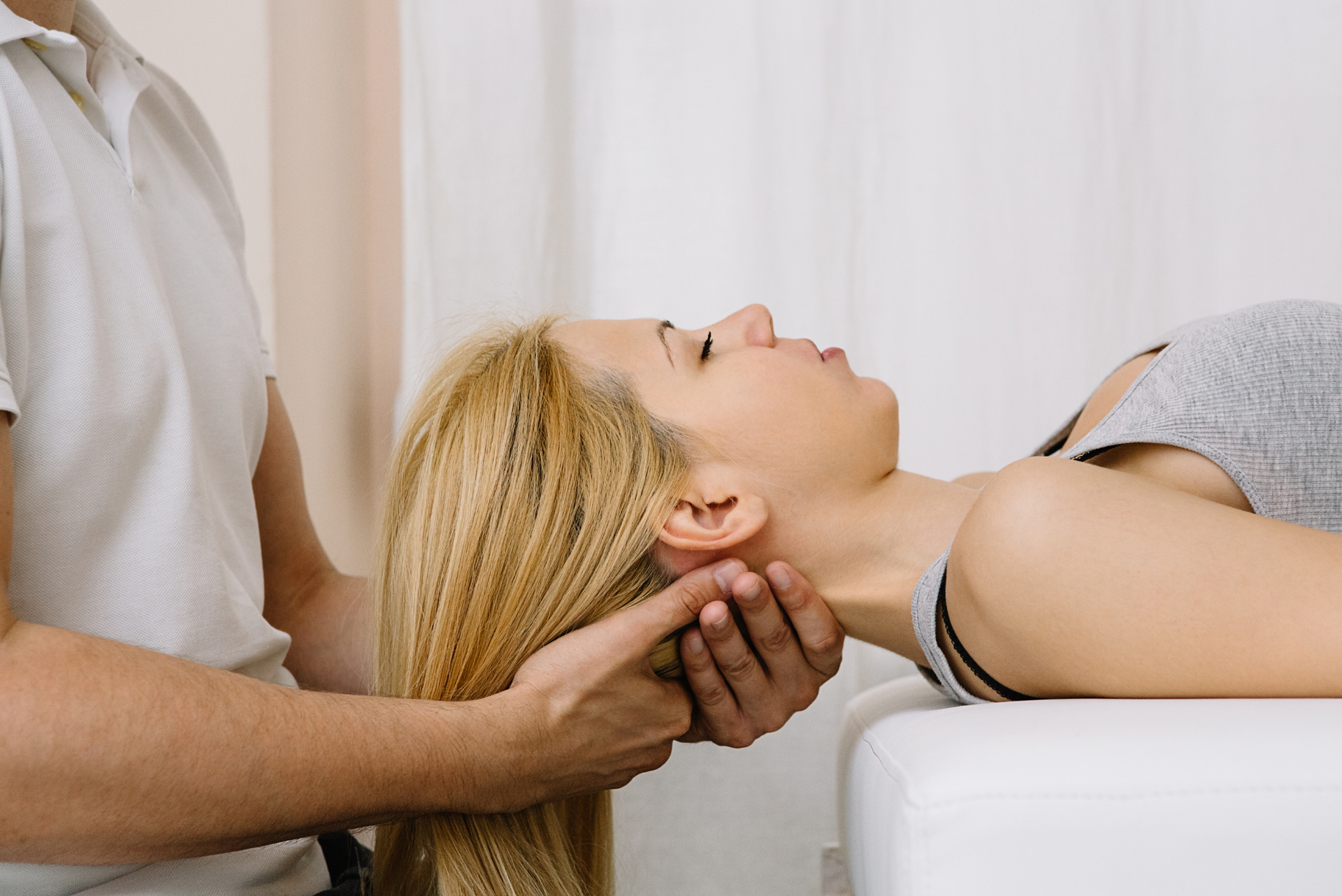 A woman is getting a neck massage from a man.