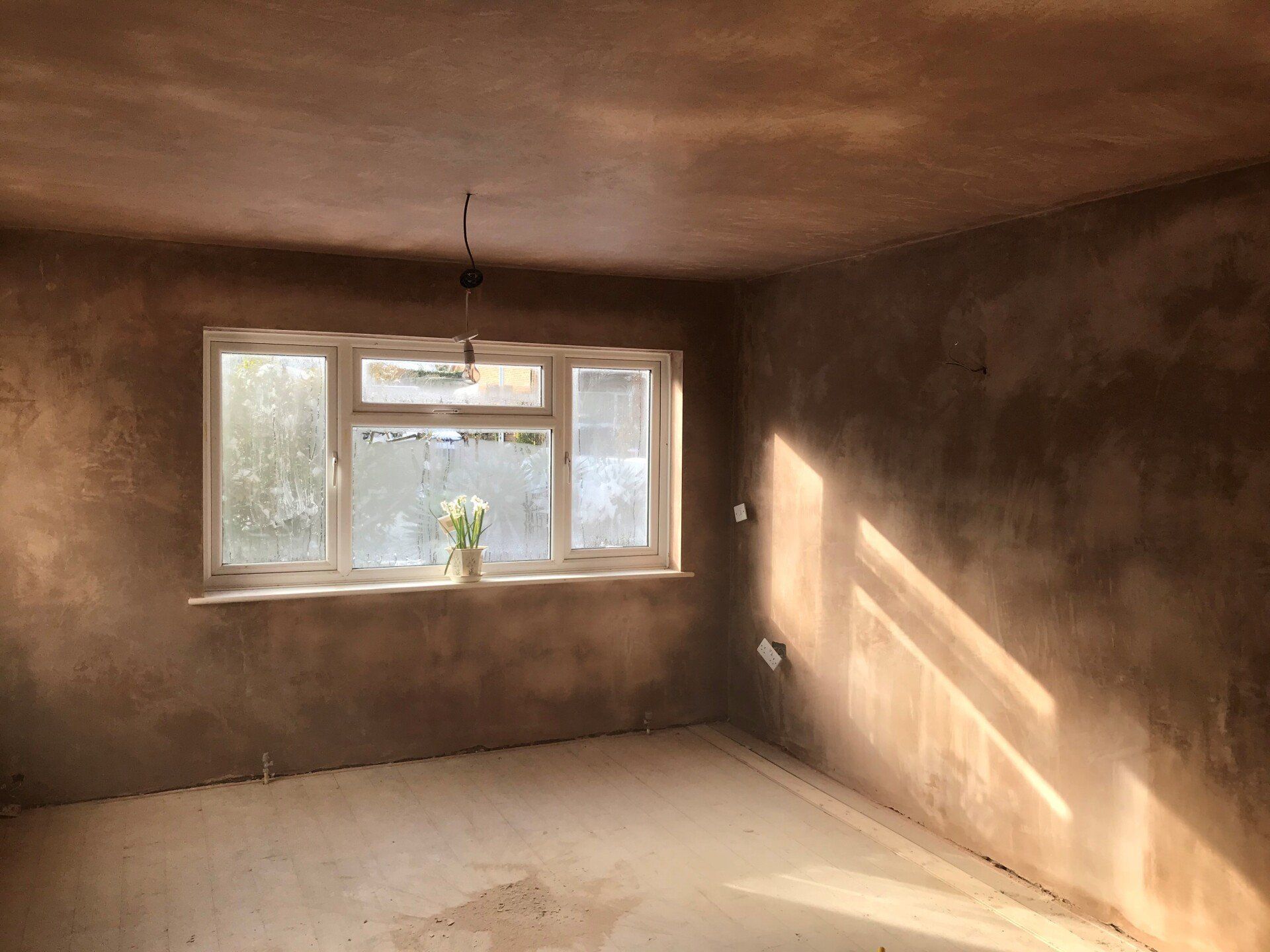a plasterer plastering walls with brown colour