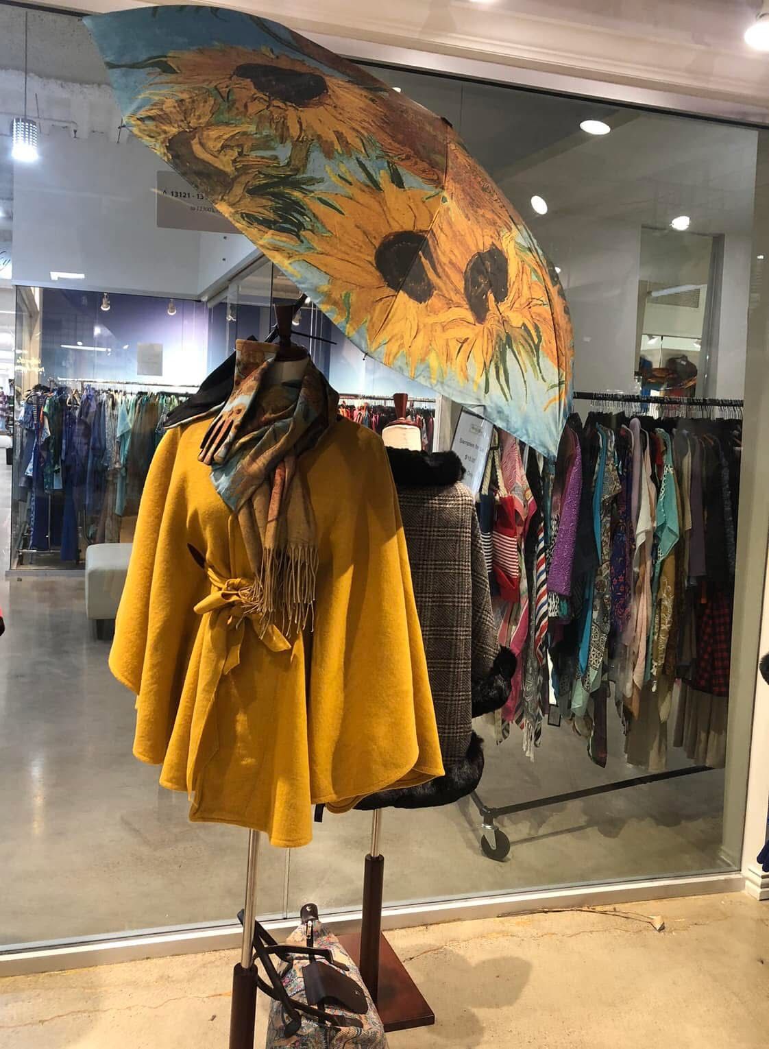 Gold necklaces draped on cream fabric, with pink flowers in background.