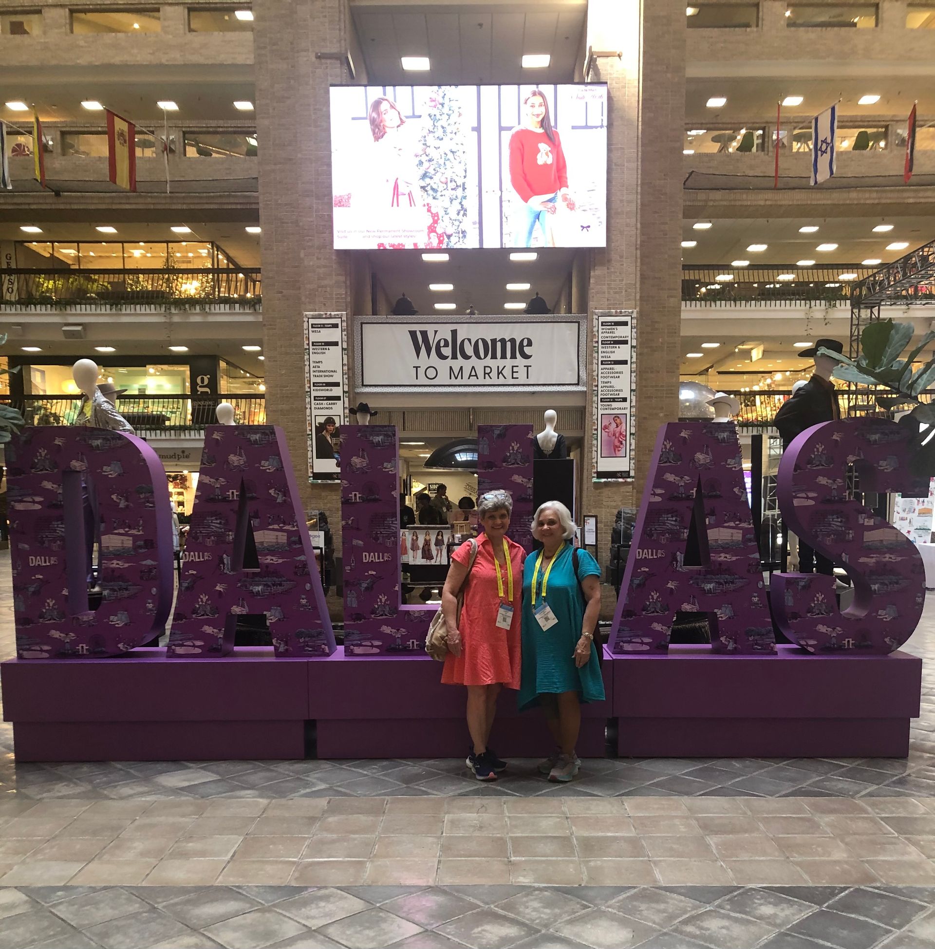 Cream-colored blouse, tan pants, purse, watch, and shoes arranged on white surface.