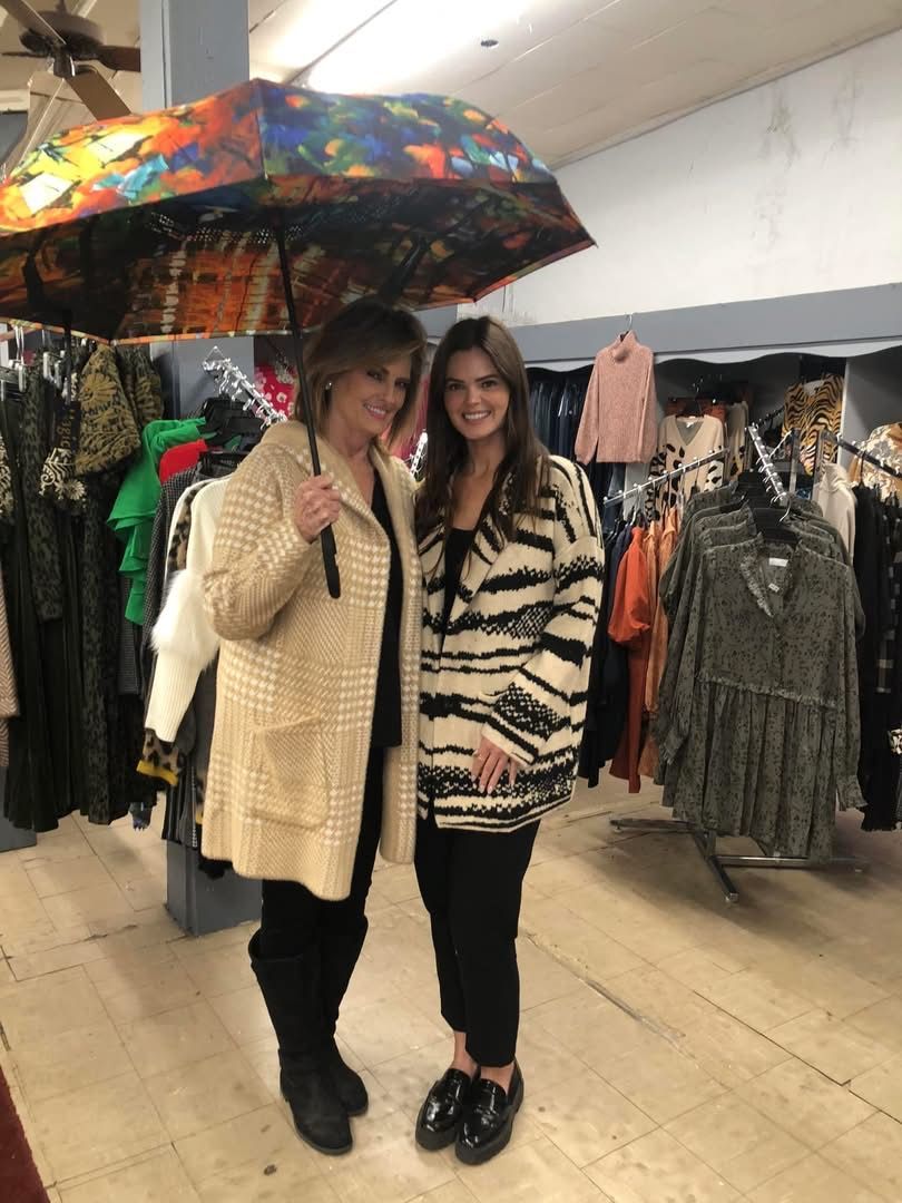 Cropped knit top in brown, white, and blue stripes on a light green blazer and blue jeans.