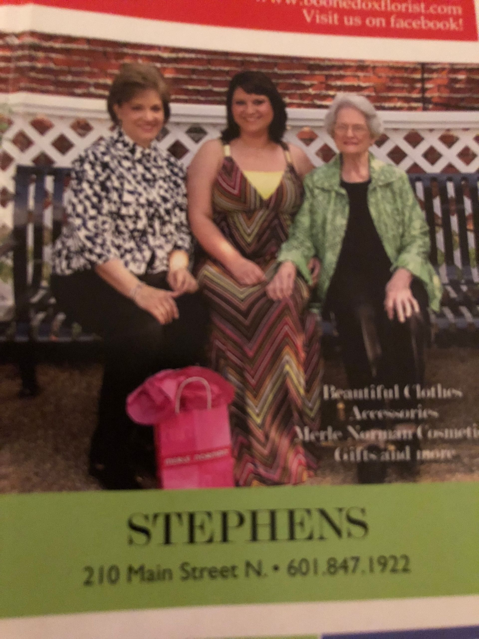 Three women on a bench, posing. Store advertisement: Stephens, 210 Main Street N.