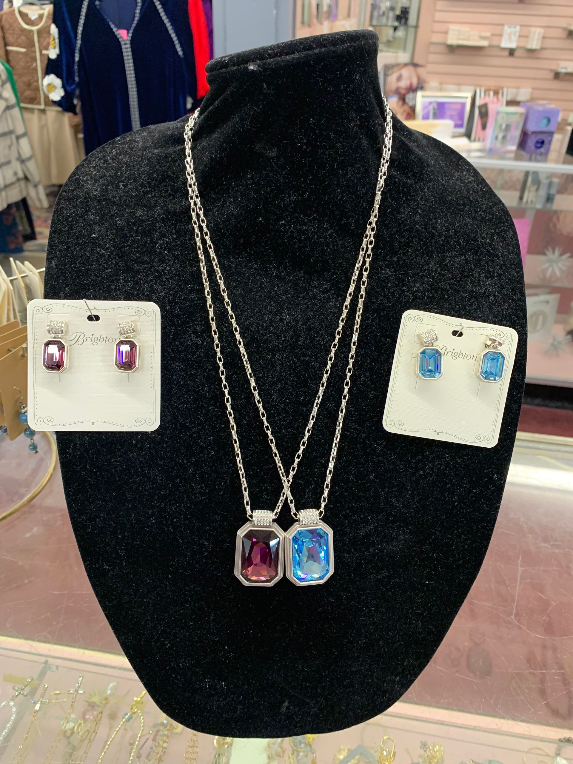Couple standing in a store; woman in checkered shirt, man in a button-down, both wearing glasses.