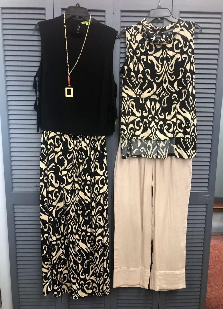 Black open-toe heeled sandals with dragonfly embellishment, on a white background.