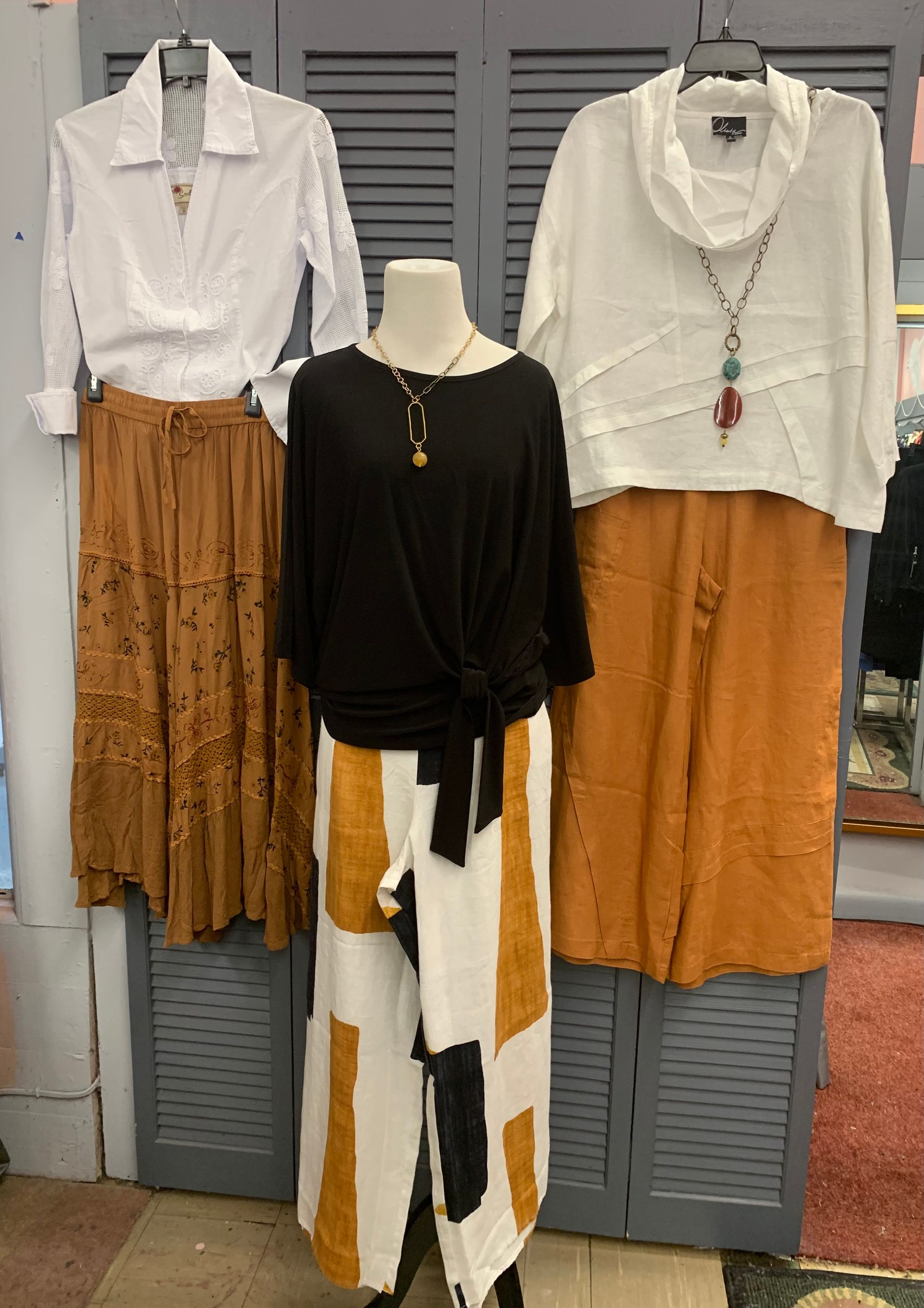 Woman in blue striped dress holding a bouquet of white roses wrapped in cellophane.