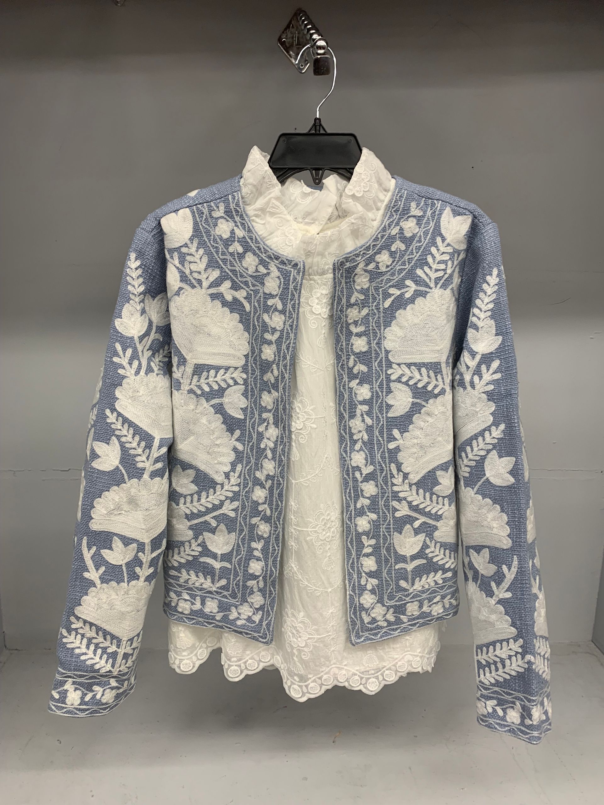 Outfit: Pink coat, cream sweater, light blue jeans, cream purse, on a marble surface.