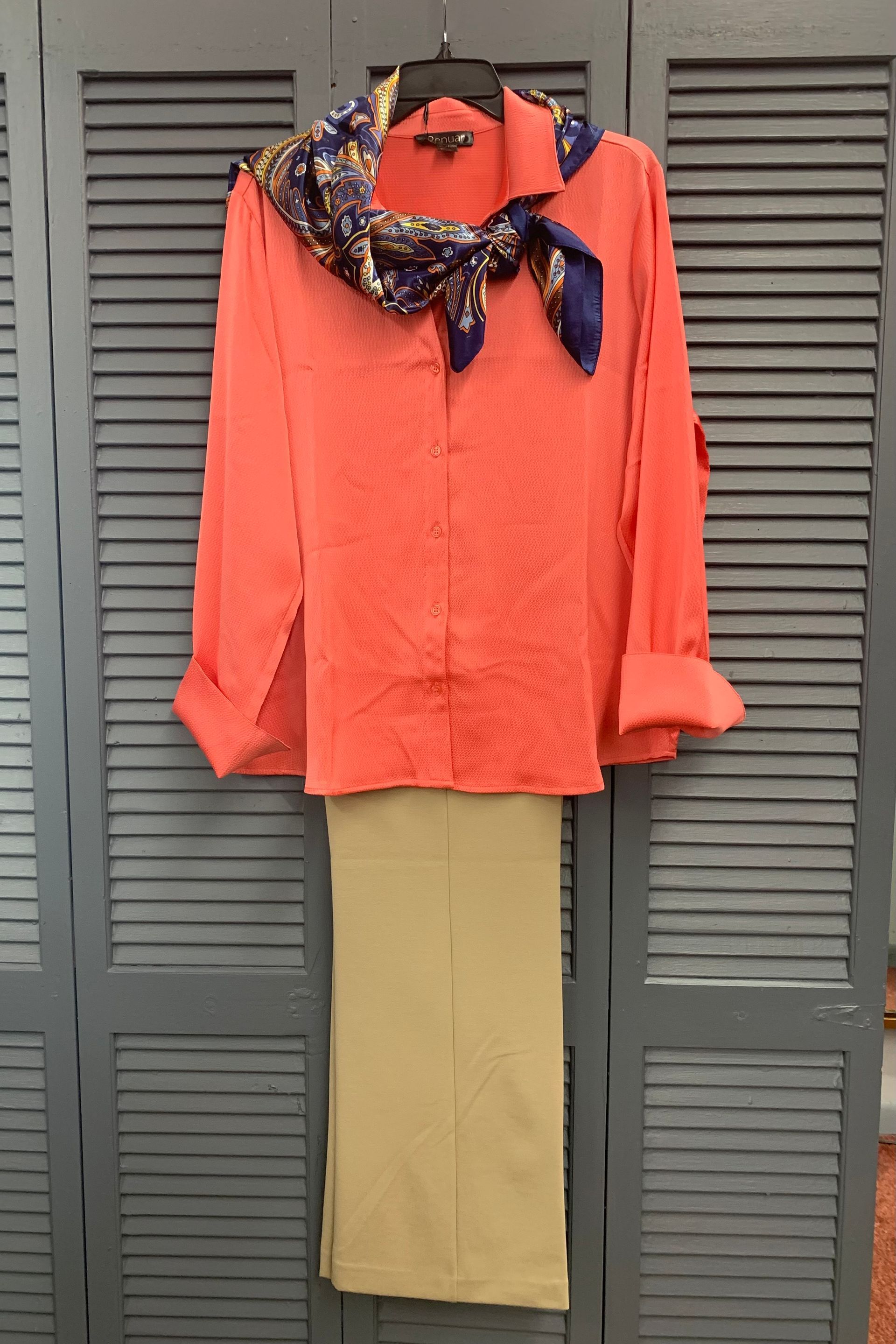 Teal winter vest, scarf, hat, and purple boots on a white wood surface.