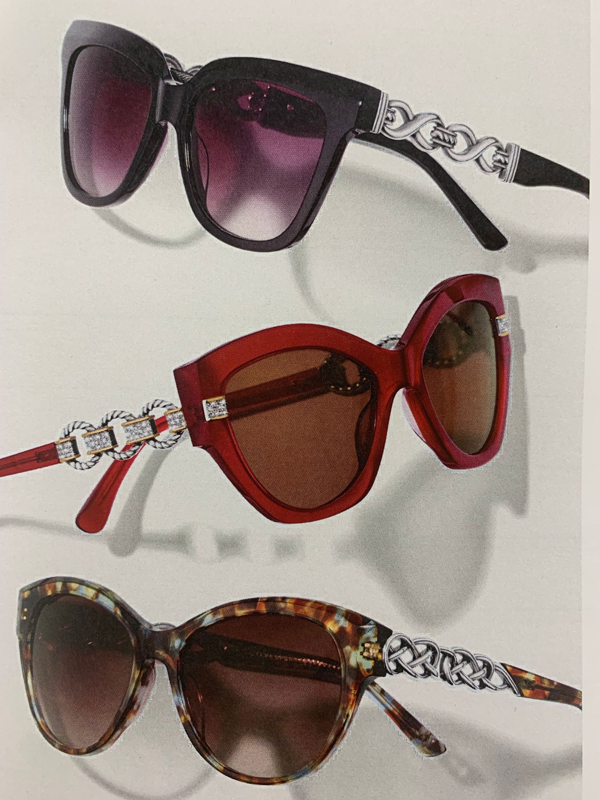 Woman wearing a beige cable-knit shirt, brown pleated skirt, and black belt, hands on hips.