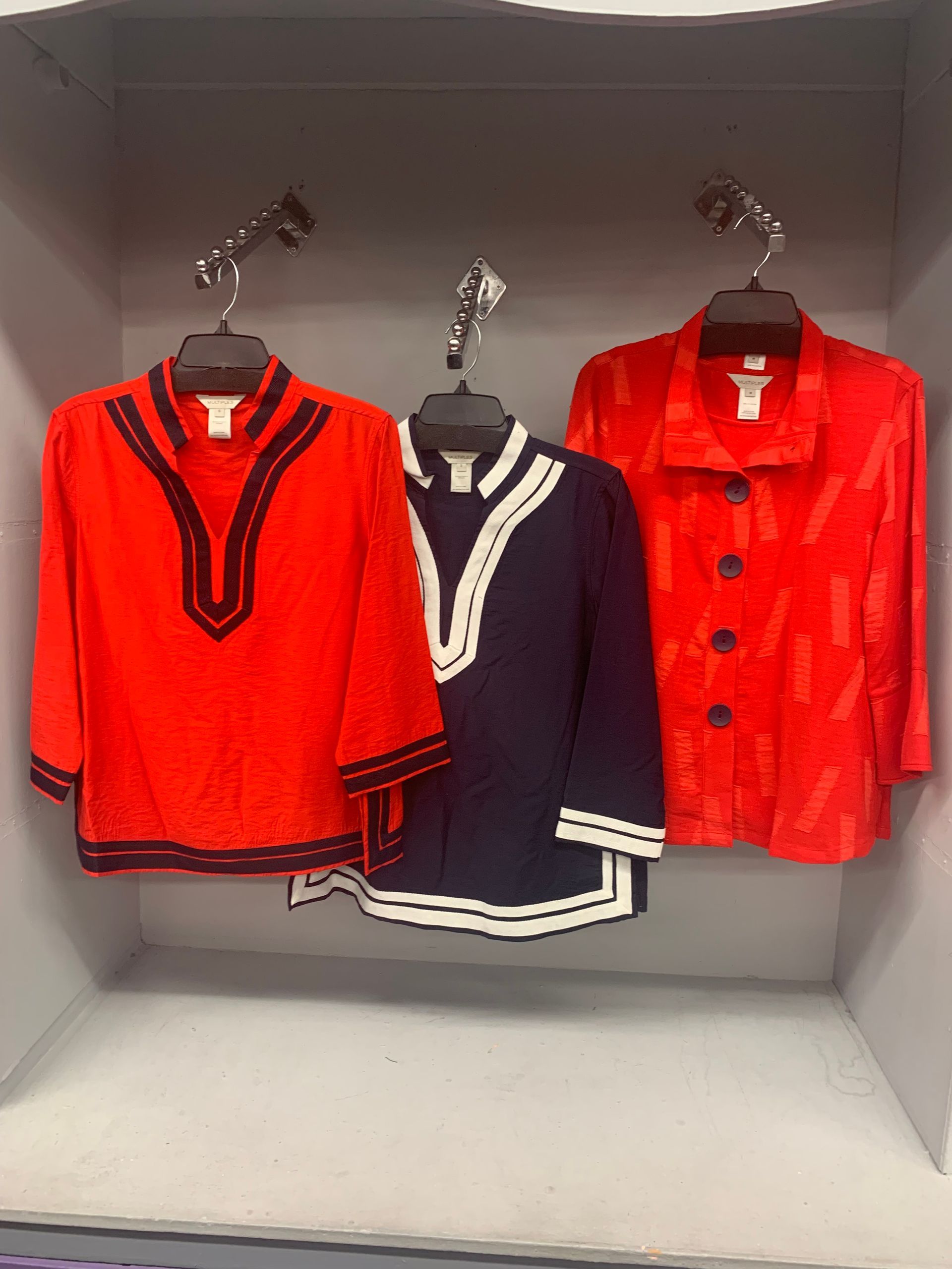 Teal puffer vest, knit scarf, hat, and purple boots on a wooden background.