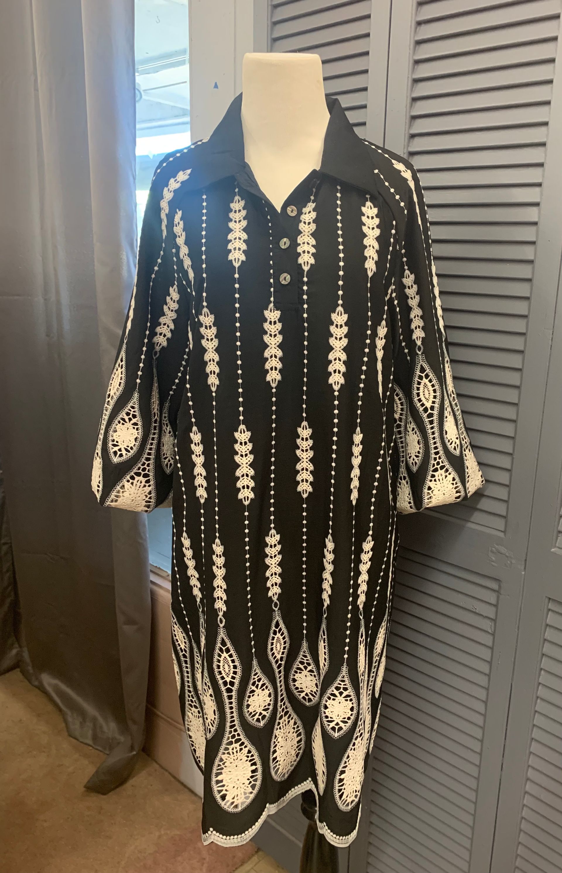 Mint green top, distressed jeans, white sneakers, hat, and branch on pink background.