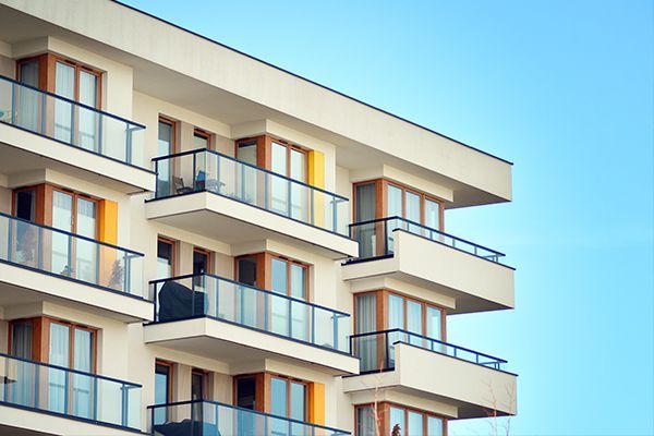 A large apartment building with lots of balconies and windows.
