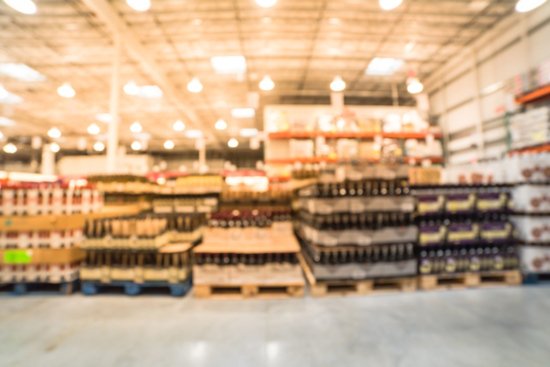 Warehouse interior, shelves and pallets of goods, blurry and out of focus.