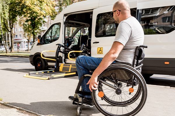 A man in a wheelchair is sitting in front of a handicap van.