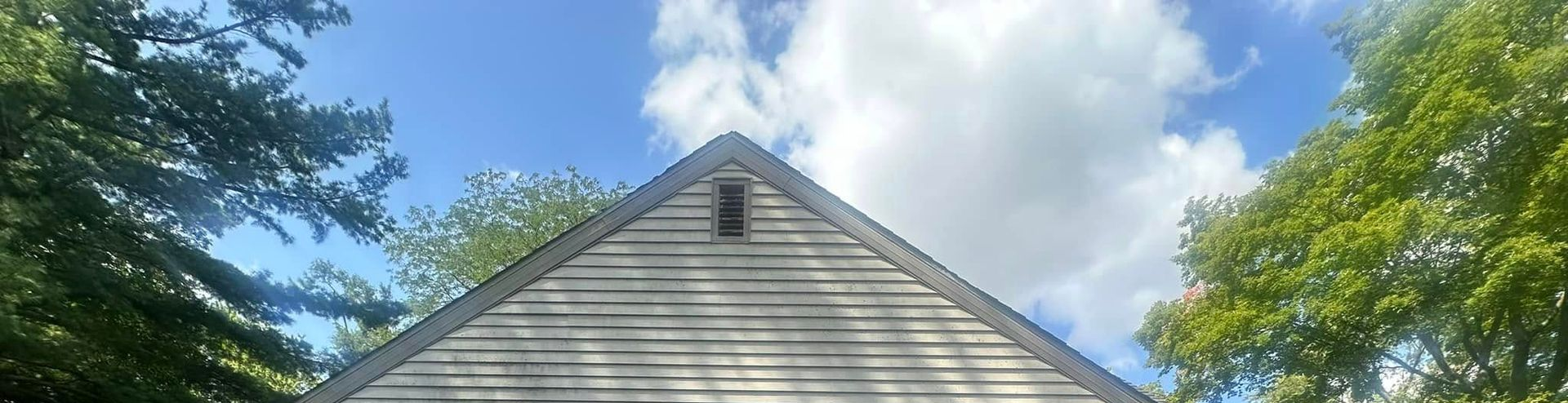 Attic with wooden beams, insulation, and yellow blocks supporting metal joist hangers.