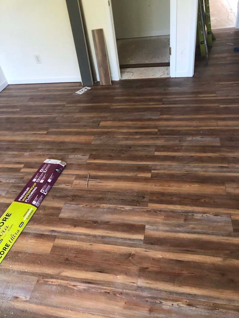 A room with a wooden floor and a yellow bag on the floor.