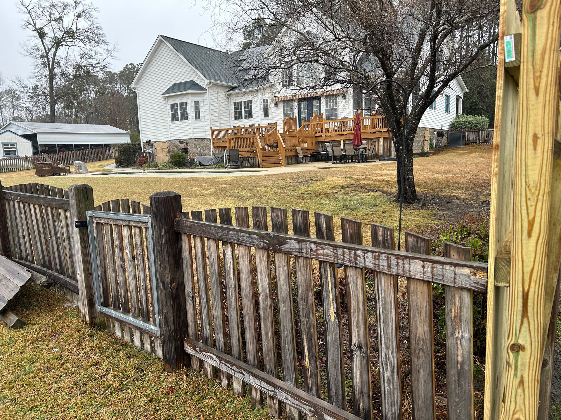 A man is working on a wooden deck next to a trailer.