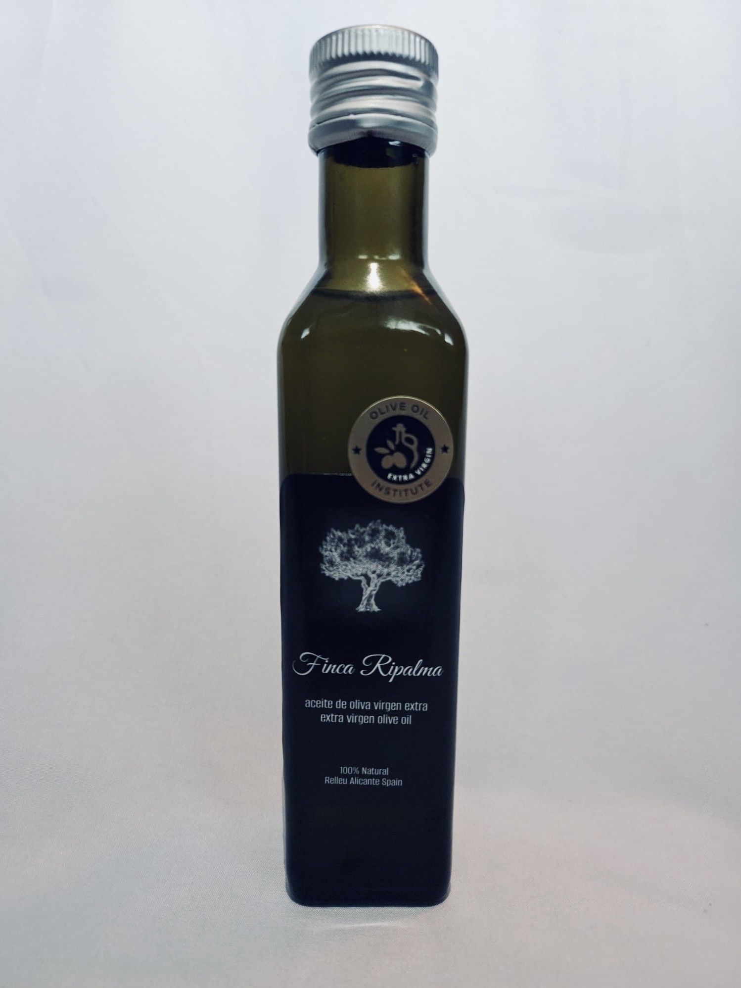 Fles olijfolie met zwart etiket en zilveren dop. Tekst 