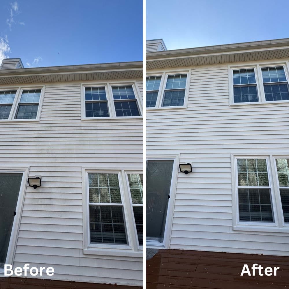 Side-by-side comparison of a house exterior before and after pressure washing. White siding, blue sky.