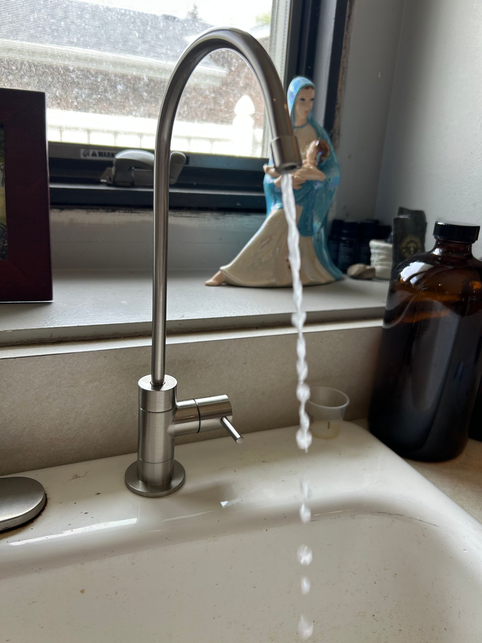 Hand turning a red valve on a corroded gas pipe in an attic. Yellow gas line visible.