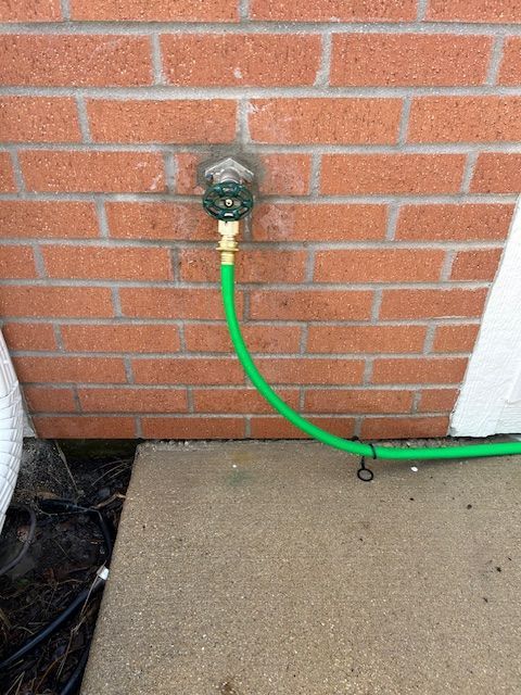 Plumber assembling pipes in a bathroom. Tools and a toilet are visible.