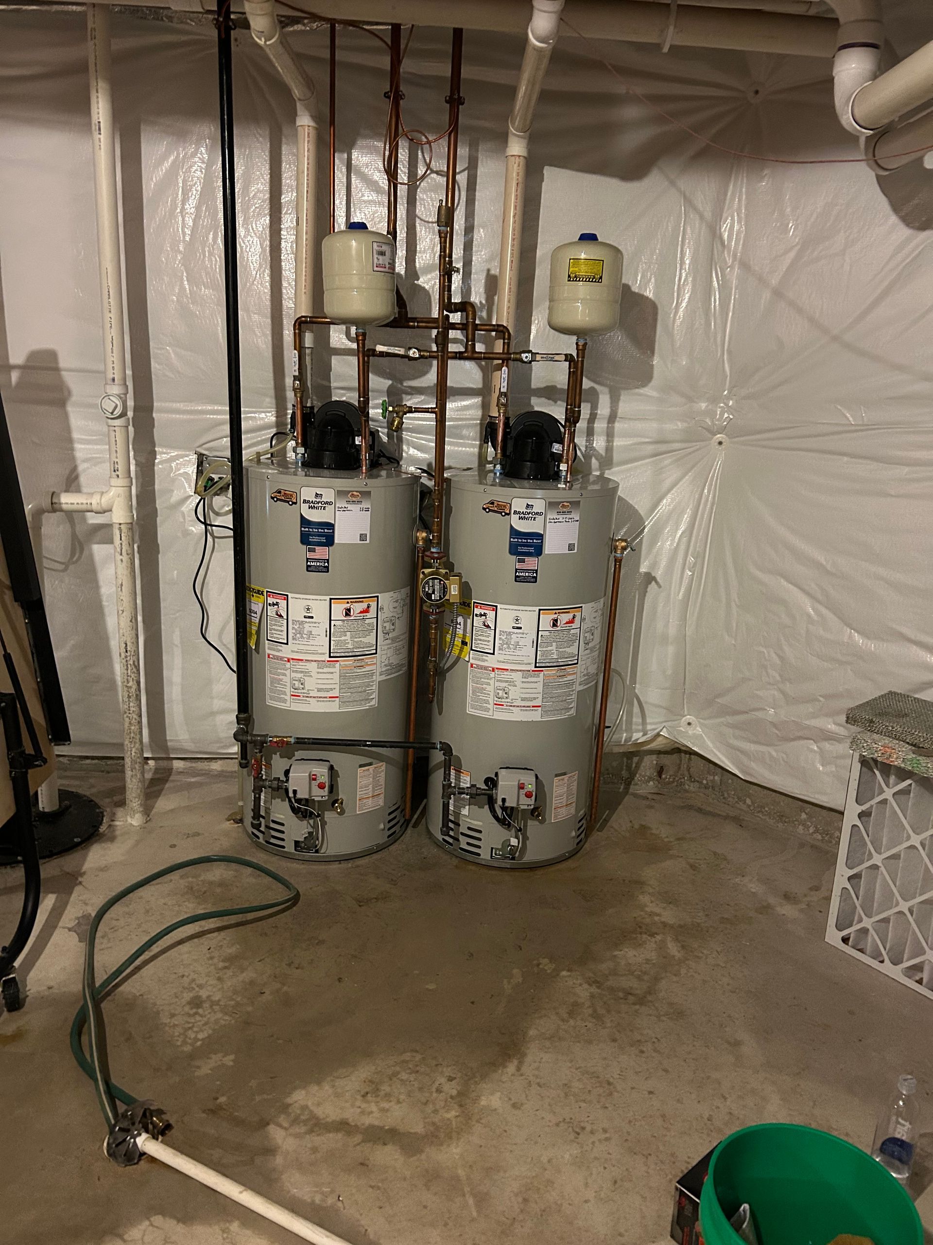 Person opening the cover of a white water heater mounted on a wall.